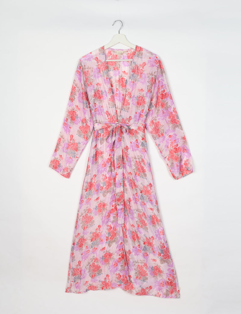 Pink floral beach robe with long sleeves and waist tie, hanging on white hanger against white background