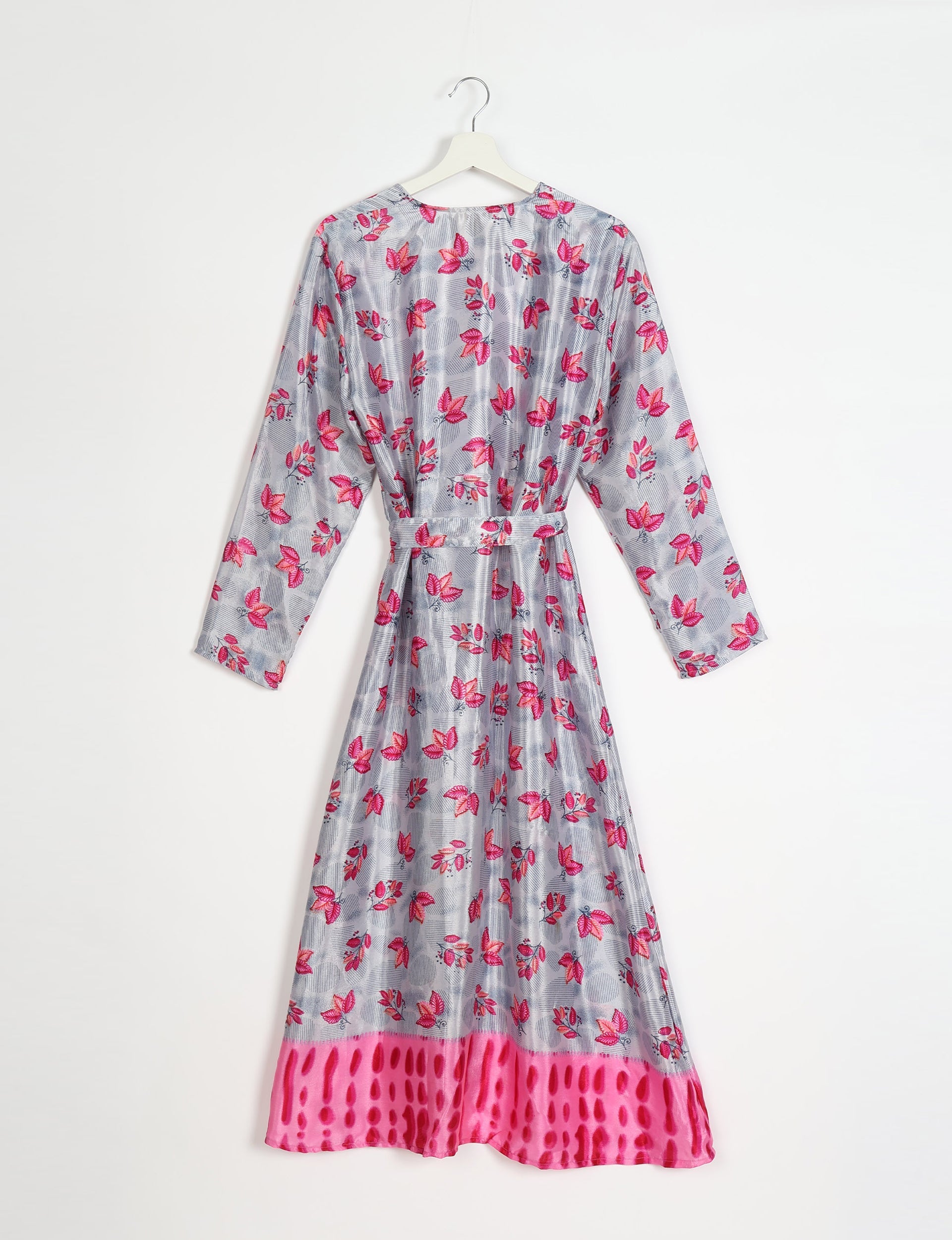Long-sleeve beach robe with pink leaf print on gray background and bright pink patterned hem, hanging on white hanger