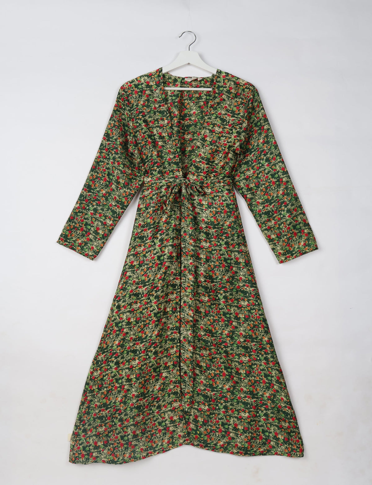 Green beach robe with abstract red and beige floral pattern, long sleeves, V-neck, and waist tie, hanging on white hanger