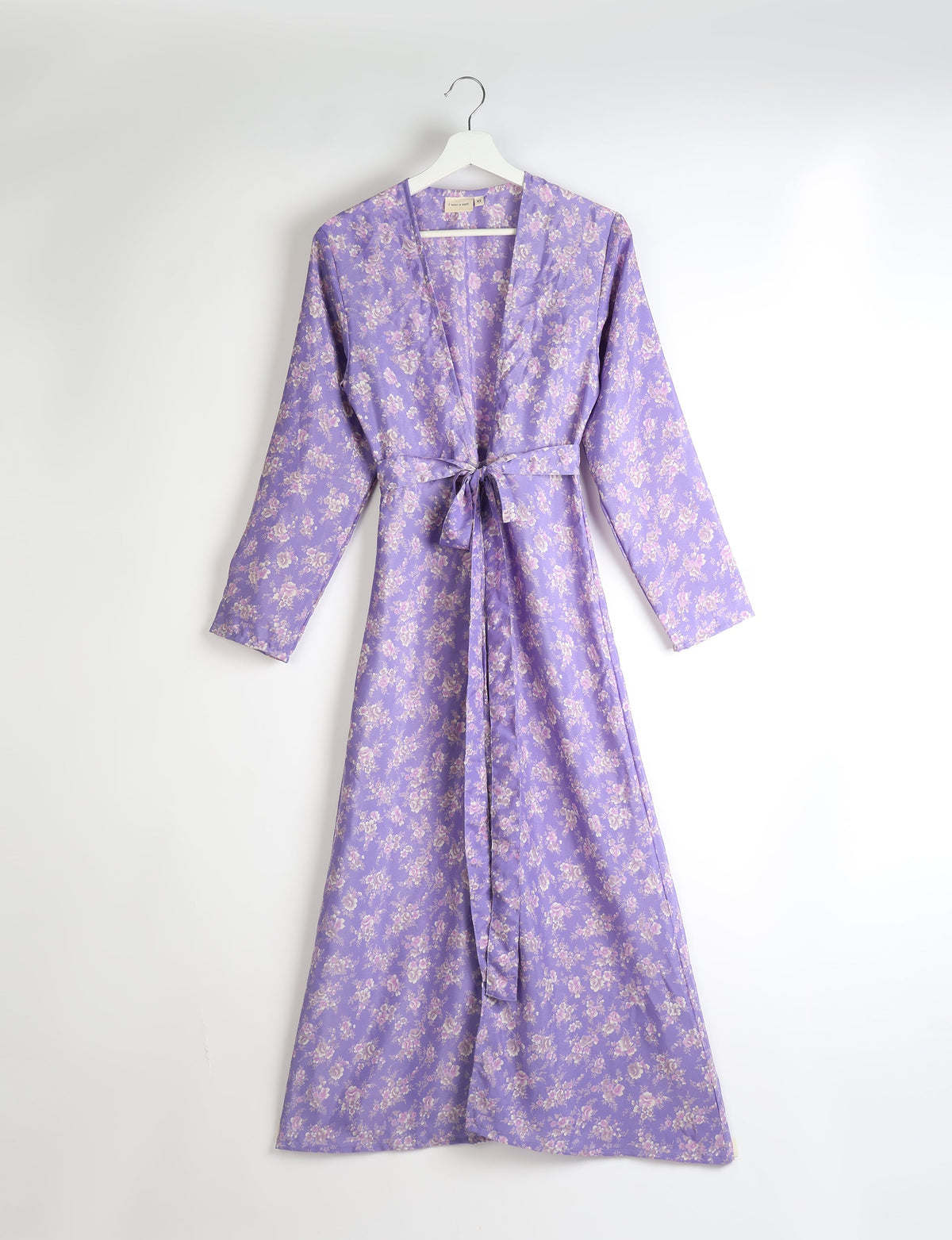 Purple floral beach robe with long sleeves and waist tie, hanging on white hanger, size XS visible on label