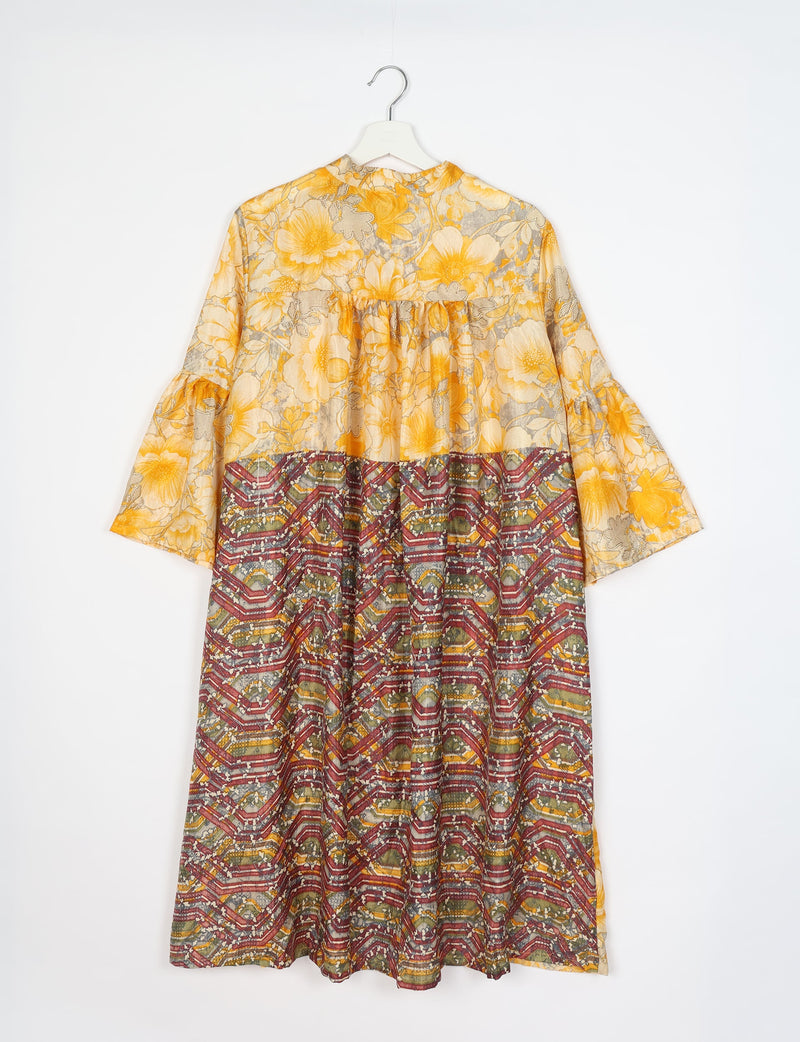 Yellow floral bell sleeve coat with mixed floral and geometric patterns hanging on white hanger, back view