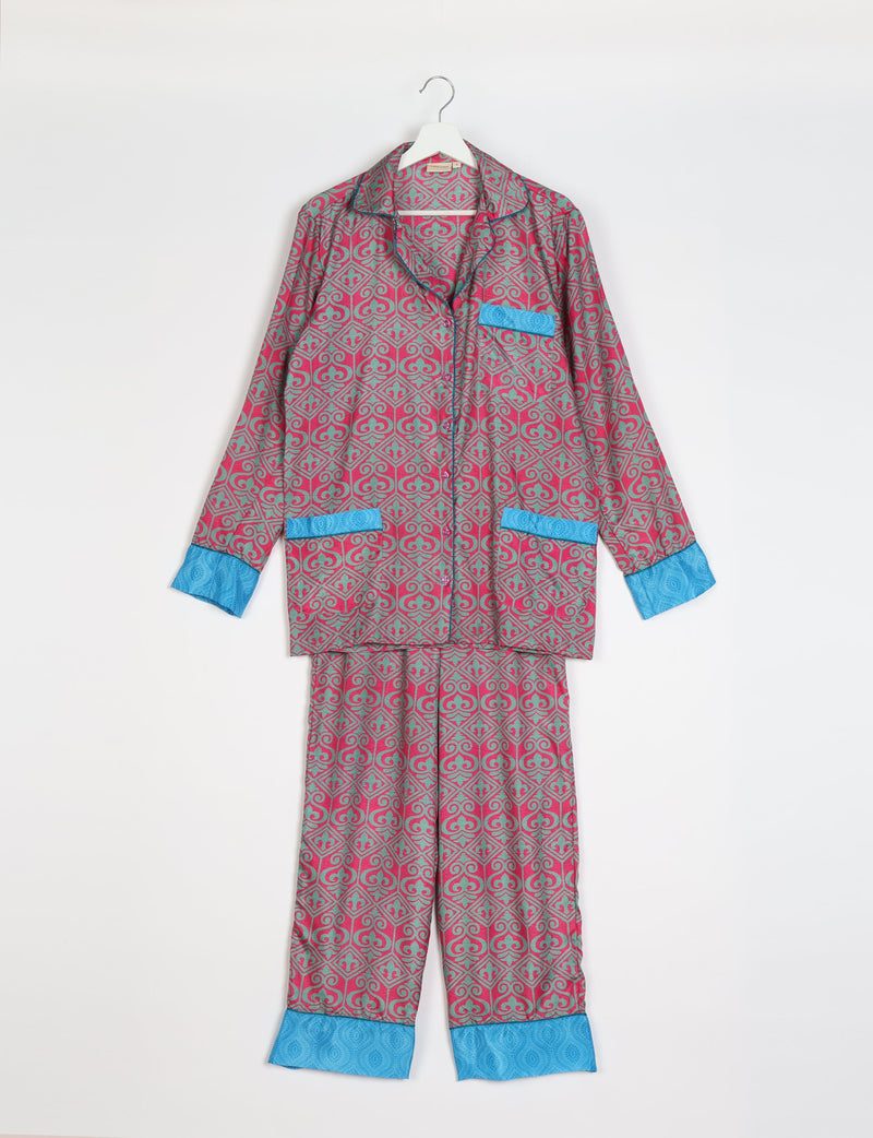Pink and gray Indian ethnic patterned long-sleeve pajama set with blue cuffs and pocket accents, hanging flat on white background