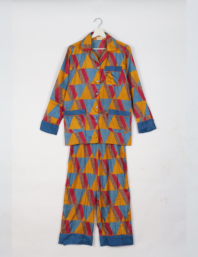 Long-sleeve yellow geometric patterned pajama set with blue patterned cuffs and pocket trim, hanging on a white hanger