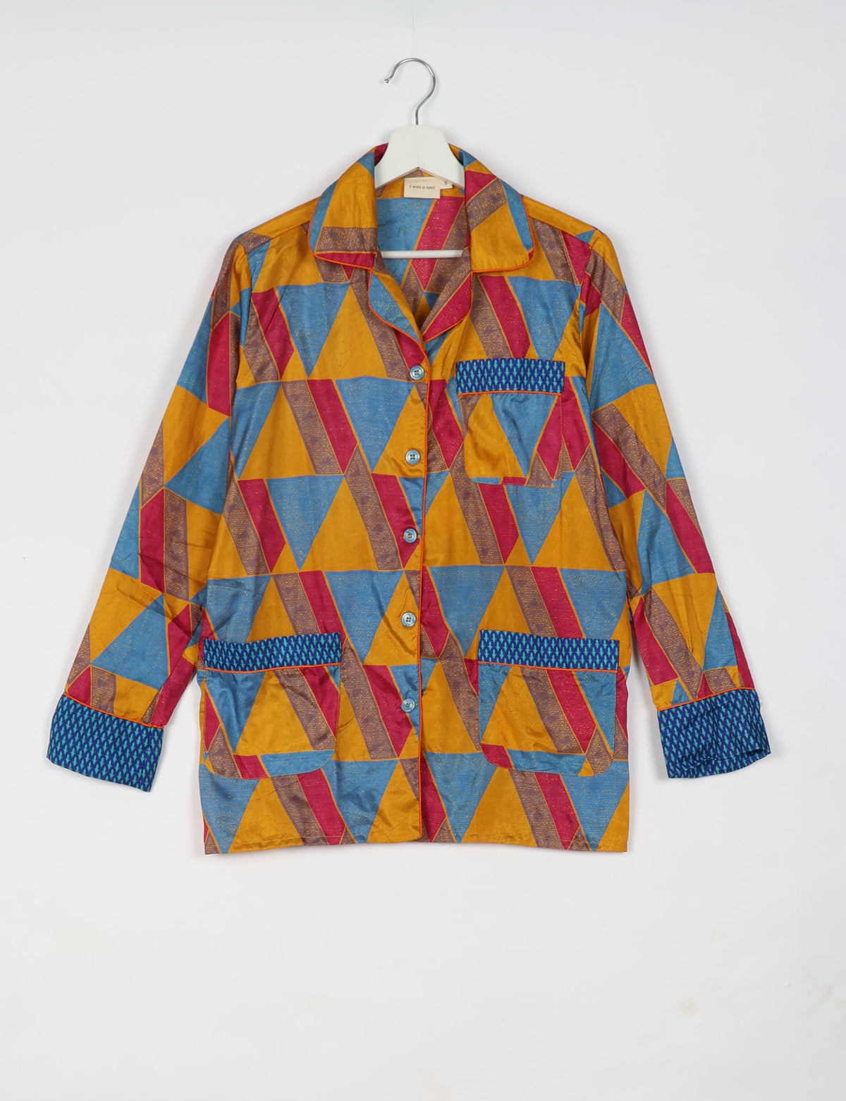 Long-sleeve yellow geometric patterned pajama top with blue and red triangles, button front, and contrasting blue pocket and cuffs