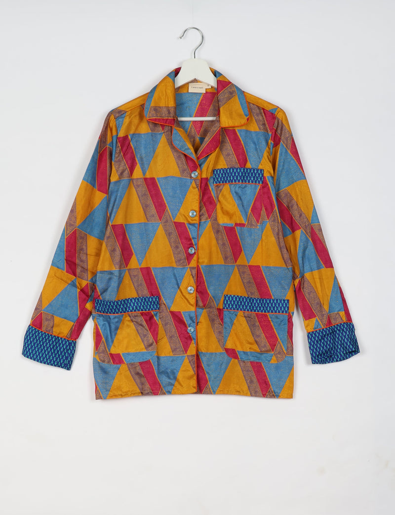 Long-sleeve yellow geometric patterned pajama top with blue and red triangles, button front, and contrasting blue pocket and cuffs