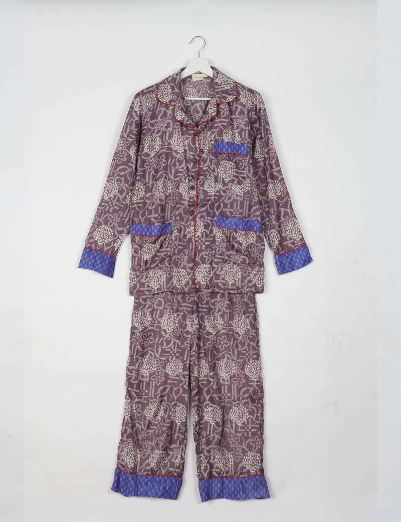 Purple floral long-sleeve pajama set with blue patterned cuffs and pocket trim, button front, hanging on white hanger