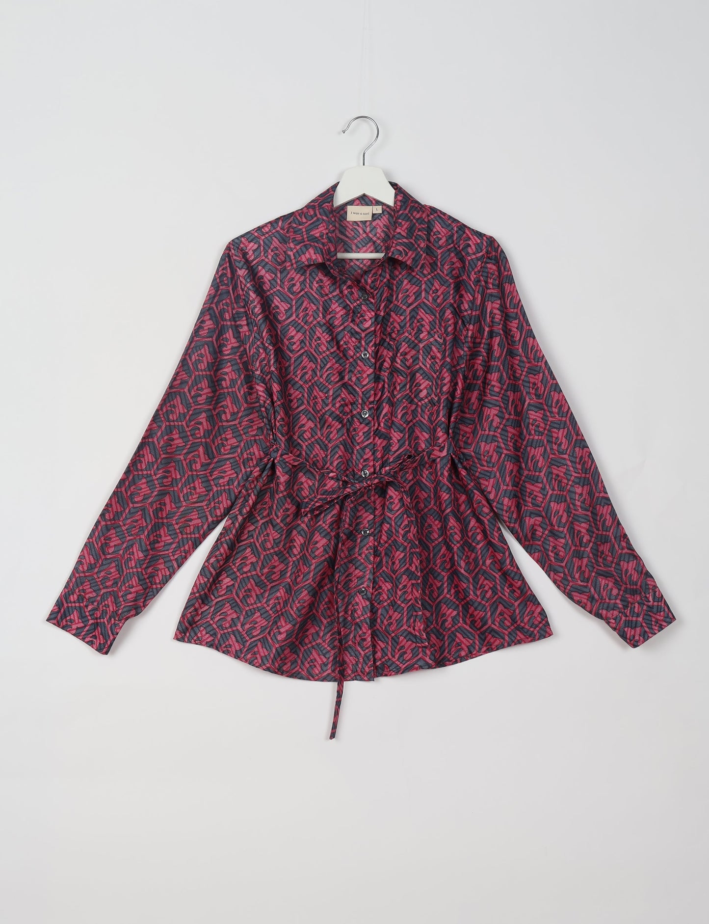 Experience sustainable fashion with our classic slim-fit shirt, crafted with ethical and green values. The shirt, designed for minimal waste, features a tie-up waist belt or neck tie, semi-spread collar, and regular shirt cuffs. Versatile and eco-friendly, wear it tucked in, unbuttoned over a tank top, or knotted at the waist for a unique style.