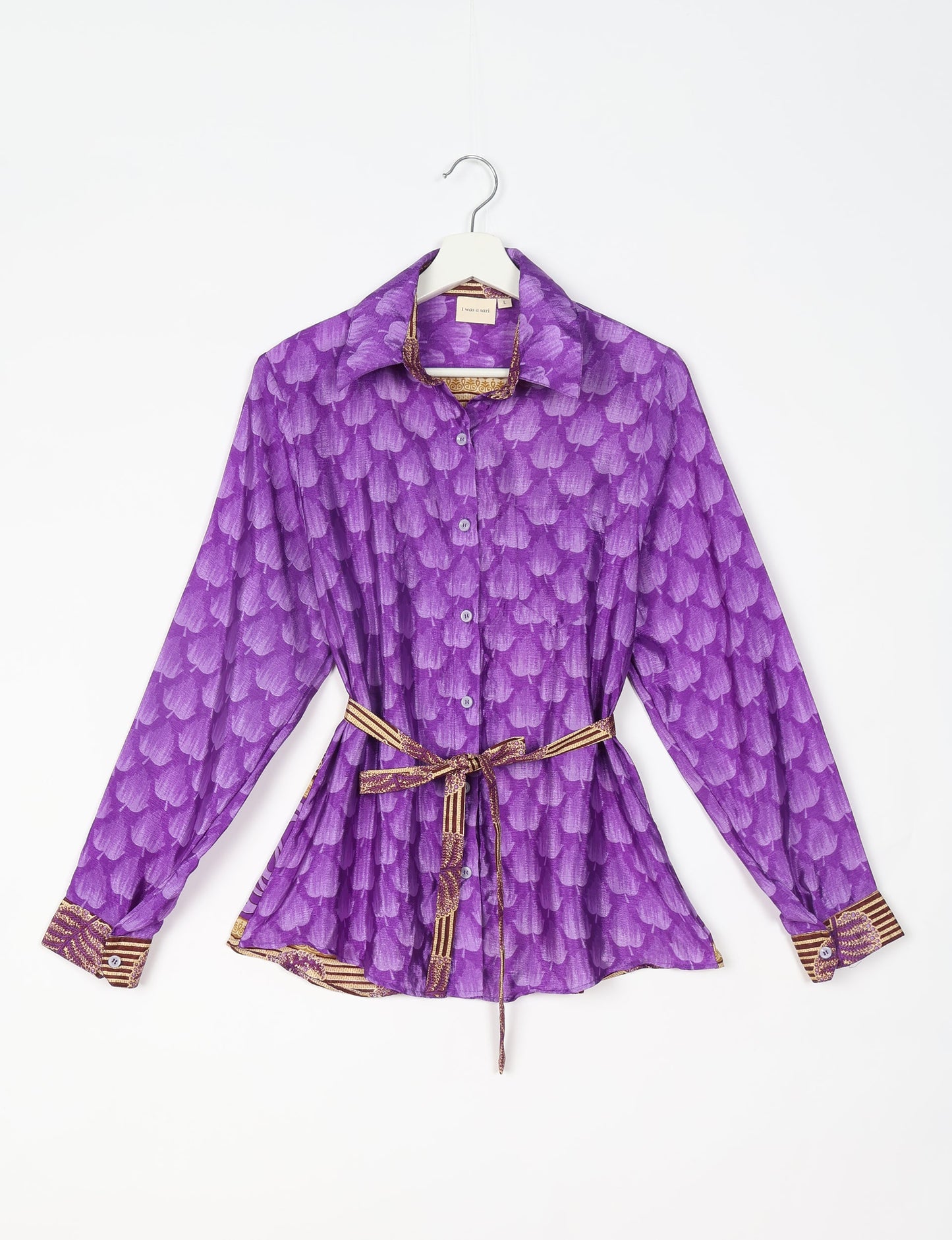 Experience sustainable fashion with our classic slim-fit shirt, crafted with ethical and green values. The shirt, designed for minimal waste, features a tie-up waist belt or neck tie, semi-spread collar, and regular shirt cuffs. Versatile and eco-friendly, wear it tucked in, unbuttoned over a tank top, or knotted at the waist for a unique style.