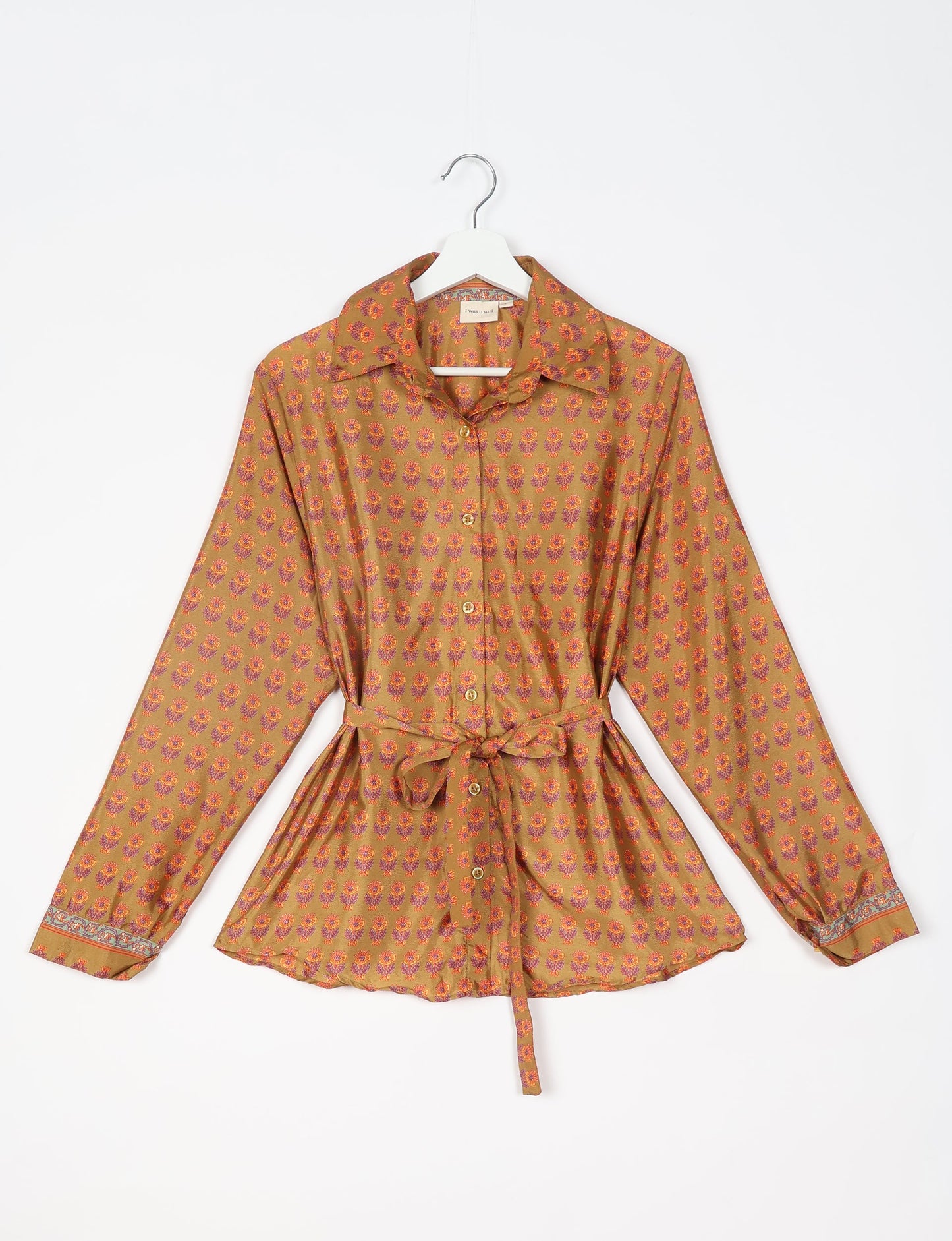 Experience sustainable fashion with our classic slim-fit shirt, crafted with ethical and green values. The shirt, designed for minimal waste, features a tie-up waist belt or neck tie, semi-spread collar, and regular shirt cuffs. Versatile and eco-friendly, wear it tucked in, unbuttoned over a tank top, or knotted at the waist for a unique style.