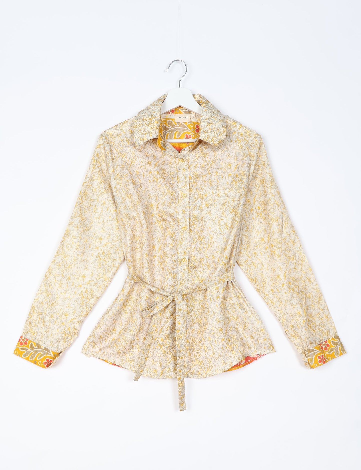 Experience sustainable fashion with our classic slim-fit shirt, crafted with ethical and green values. The shirt, designed for minimal waste, features a tie-up waist belt or neck tie, semi-spread collar, and regular shirt cuffs. Versatile and eco-friendly, wear it tucked in, unbuttoned over a tank top, or knotted at the waist for a unique style.