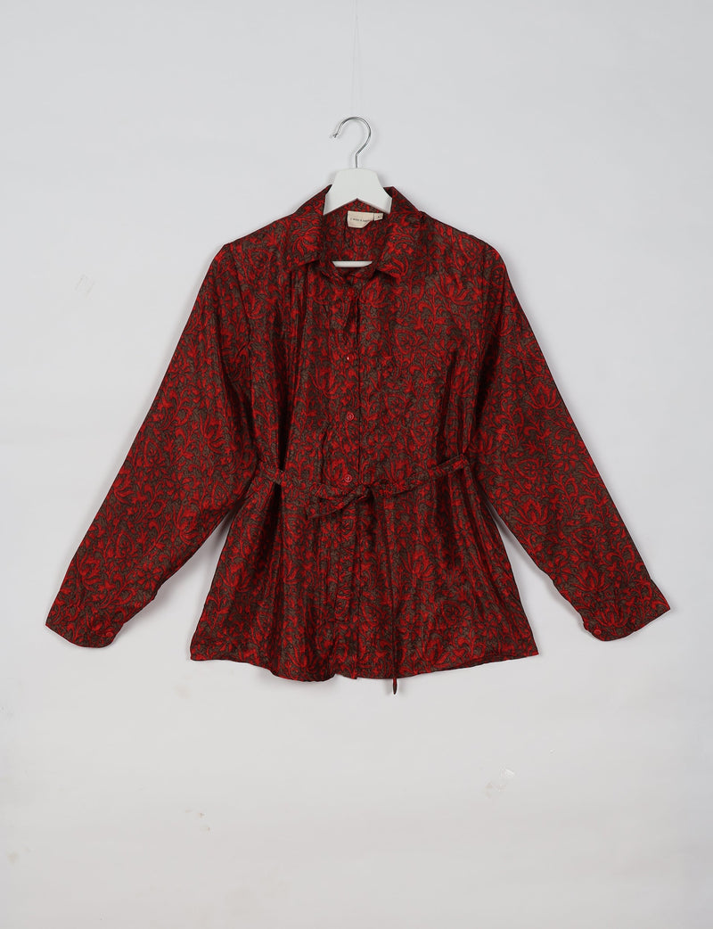 Red long-sleeve shirt with black floral pattern, button front, collar, and waist tie, hanging on white hanger