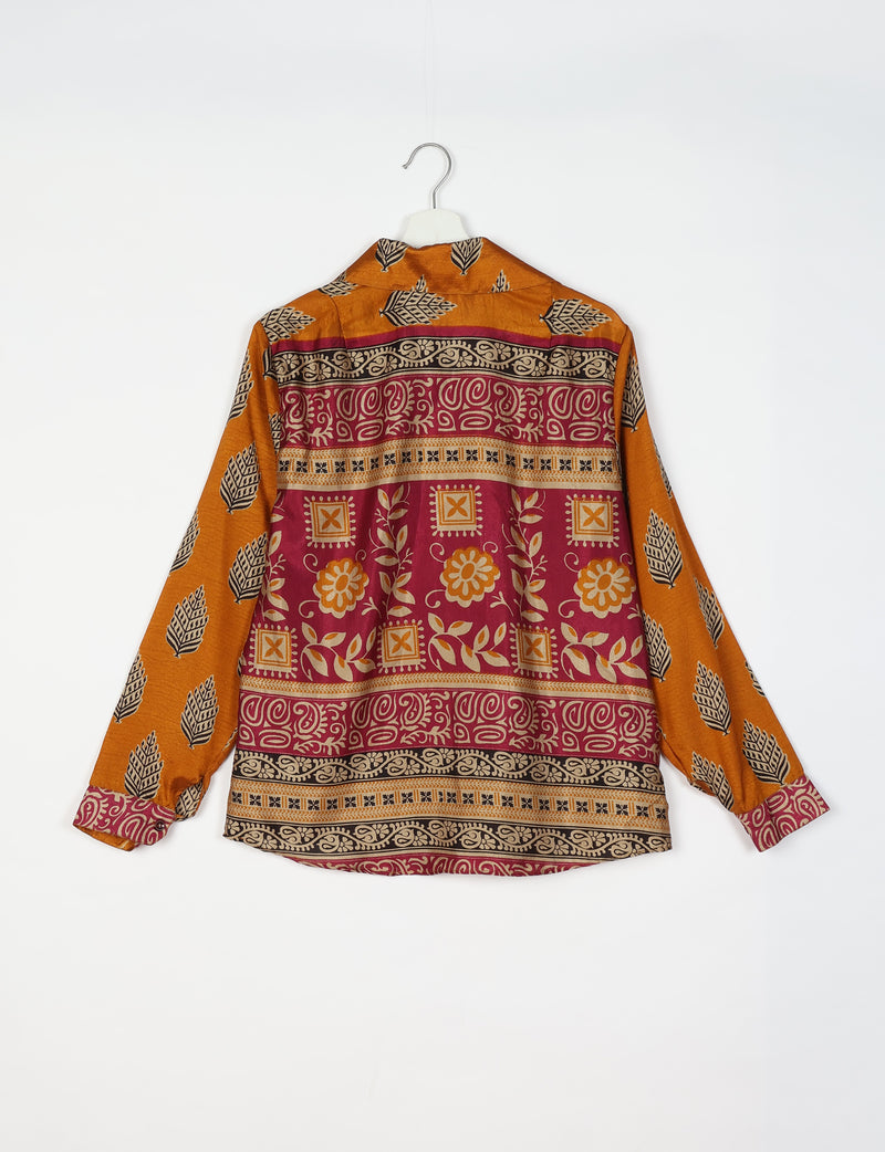Long-sleeve shirt with orange leaf pattern on sleeves and multicolor floral and geometric print on back, hanging on white hanger