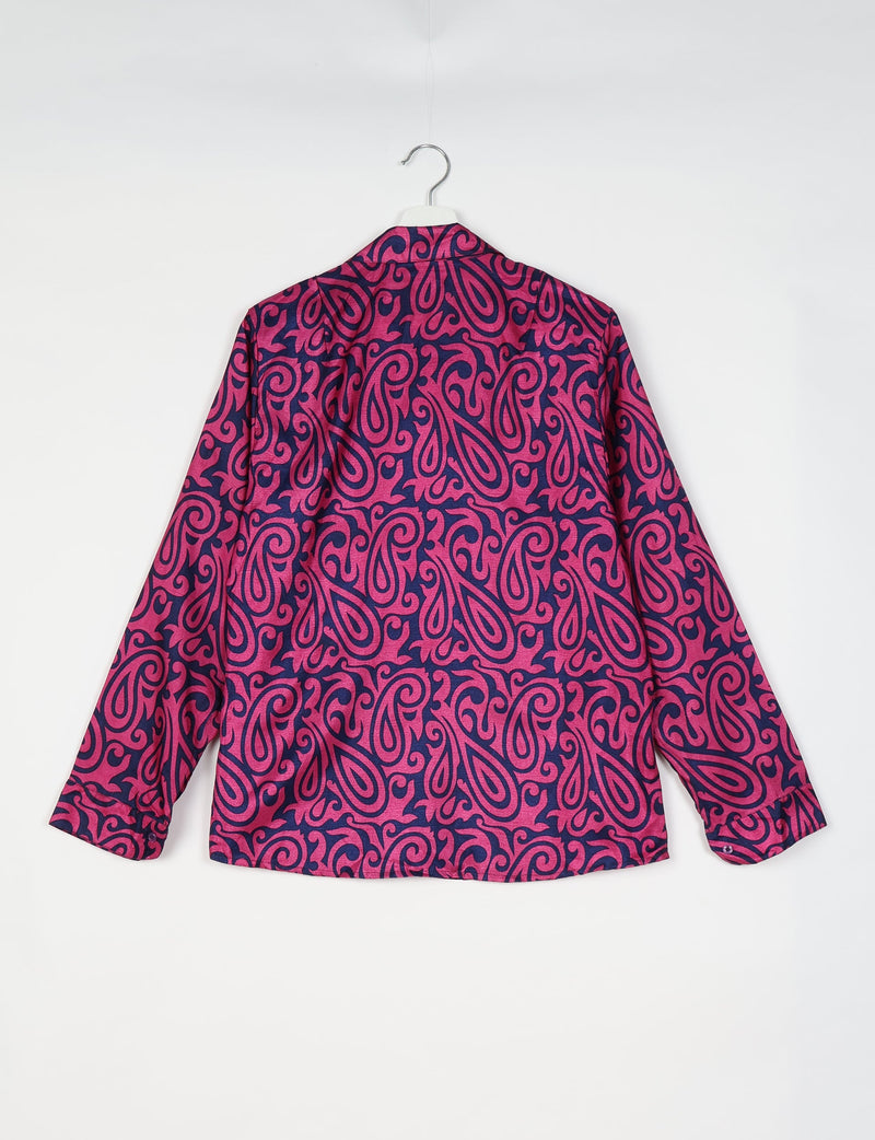 Long-sleeve shirt with pink paisley pattern on dark blue fabric, shown from back, hanging on white hanger