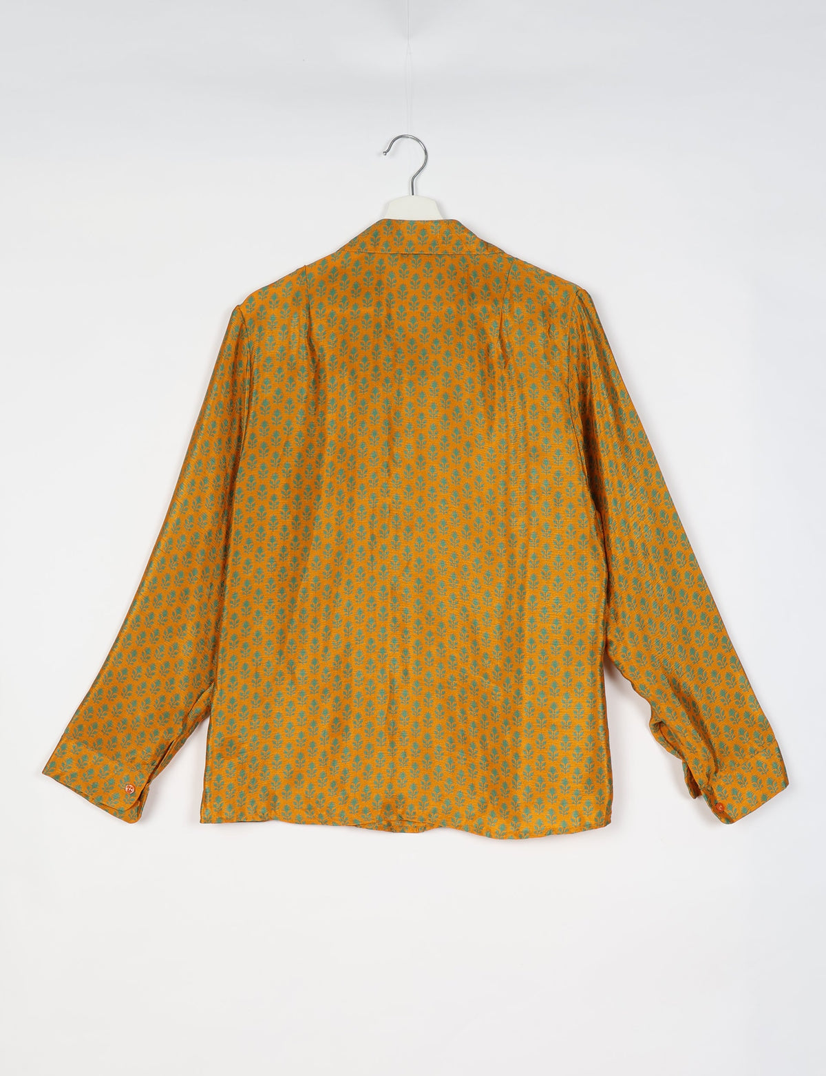 Yellow long-sleeve shirt with green micro floral pattern, buttoned cuffs, shown from back on white hanger against white background