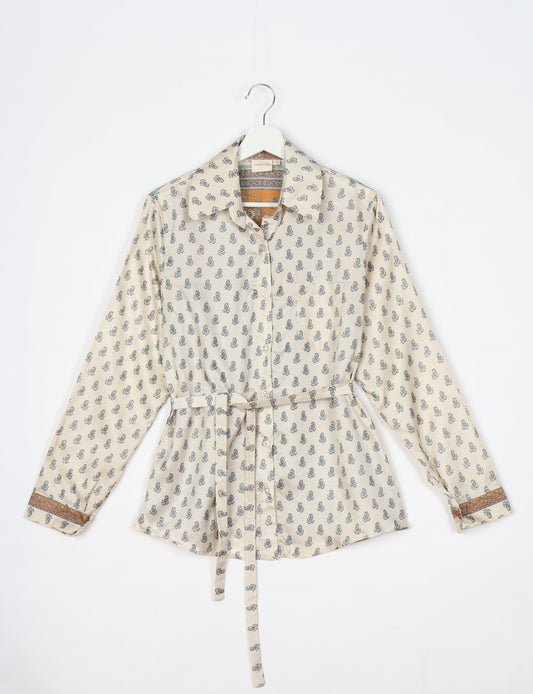 Experience sustainable fashion with our classic slim-fit shirt, crafted with ethical and green values. The shirt, designed for minimal waste, features a tie-up waist belt or neck tie, semi-spread collar, and regular shirt cuffs. Versatile and eco-friendly, wear it tucked in, unbuttoned over a tank top, or knotted at the waist for a unique style.