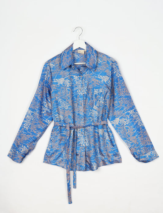 Experience sustainable fashion with our classic slim-fit shirt, crafted with ethical and green values. The shirt, designed for minimal waste, features a tie-up waist belt or neck tie, semi-spread collar, and regular shirt cuffs. Versatile and eco-friendly, wear it tucked in, unbuttoned over a tank top, or knotted at the waist for a unique style.