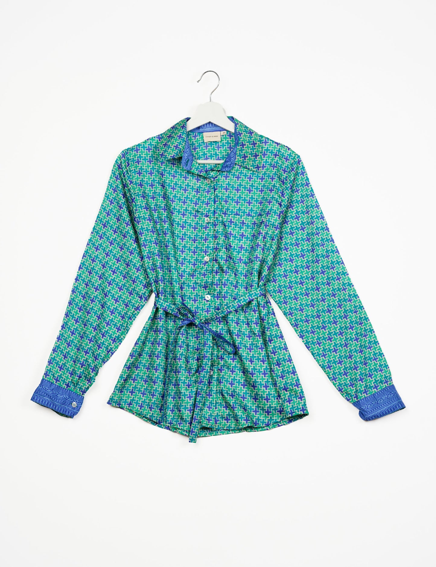 Experience sustainable fashion with our classic slim-fit shirt, crafted with ethical and green values. The shirt, designed for minimal waste, features a tie-up waist belt or neck tie, semi-spread collar, and regular shirt cuffs. Versatile and eco-friendly, wear it tucked in, unbuttoned over a tank top, or knotted at the waist for a unique style.