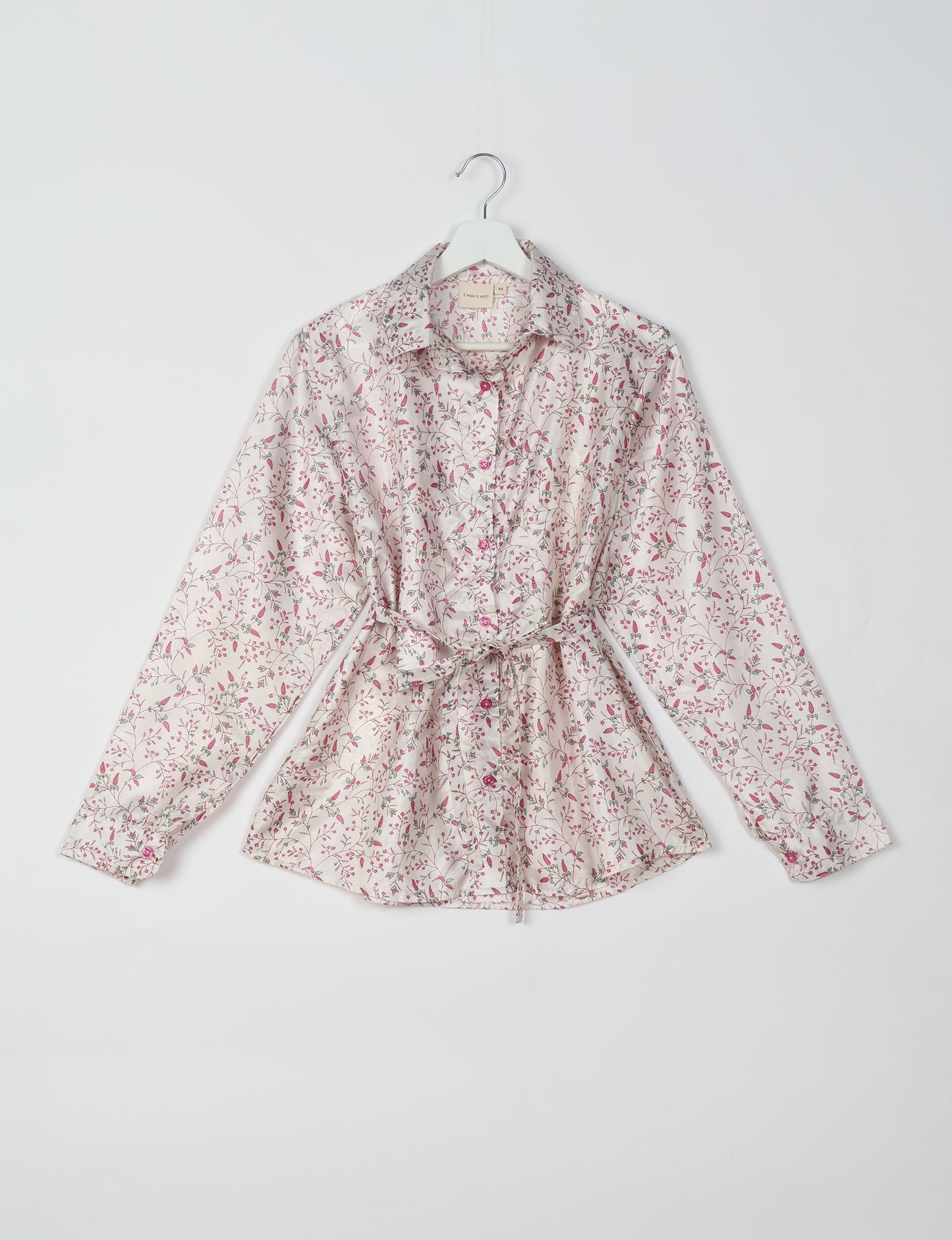 Experience sustainable fashion with our classic slim-fit shirt, crafted with ethical and green values. The shirt, designed for minimal waste, features a tie-up waist belt or neck tie, semi-spread collar, and regular shirt cuffs. Versatile and eco-friendly, wear it tucked in, unbuttoned over a tank top, or knotted at the waist for a unique style.