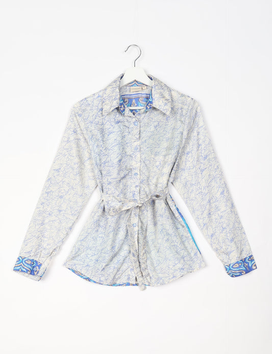 Experience sustainable fashion with our classic slim-fit shirt, crafted with ethical and green values. The shirt, designed for minimal waste, features a tie-up waist belt or neck tie, semi-spread collar, and regular shirt cuffs. Versatile and eco-friendly, wear it tucked in, unbuttoned over a tank top, or knotted at the waist for a unique style.