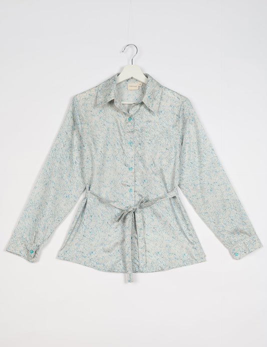 Experience sustainable fashion with our classic slim-fit shirt, crafted with ethical and green values. The shirt, designed for minimal waste, features a tie-up waist belt or neck tie, semi-spread collar, and regular shirt cuffs. Versatile and eco-friendly, wear it tucked in, unbuttoned over a tank top, or knotted at the waist for a unique style.