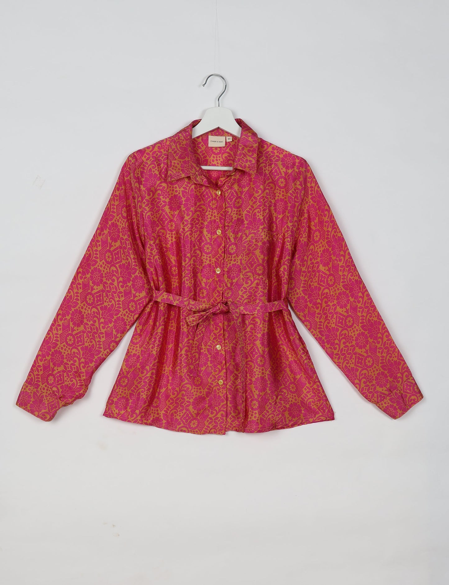 Experience sustainable fashion with our classic slim-fit shirt, crafted with ethical and green values. The shirt, designed for minimal waste, features a tie-up waist belt or neck tie, semi-spread collar, and regular shirt cuffs. Versatile and eco-friendly, wear it tucked in, unbuttoned over a tank top, or knotted at the waist for a unique style.