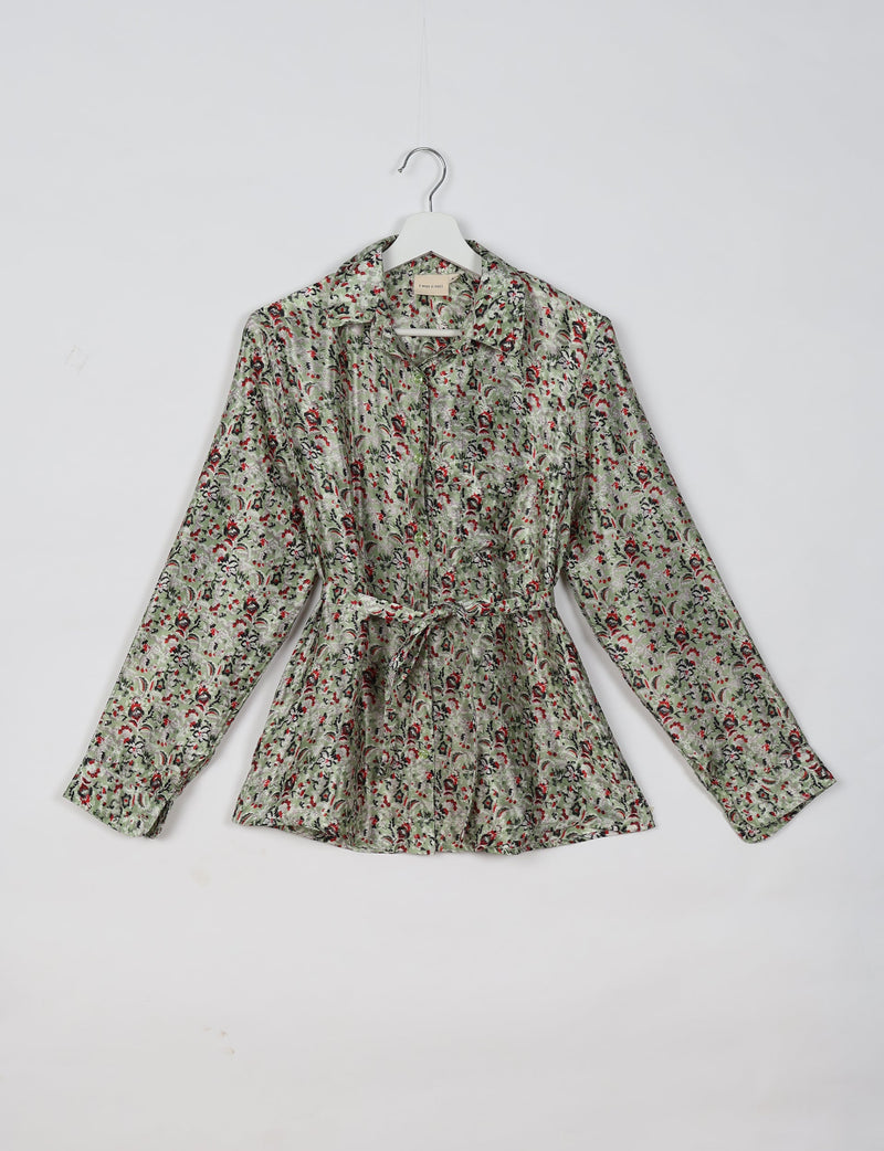Beige tropical print long-sleeve shirt with collar and waist tie, hanging on white hanger against white background