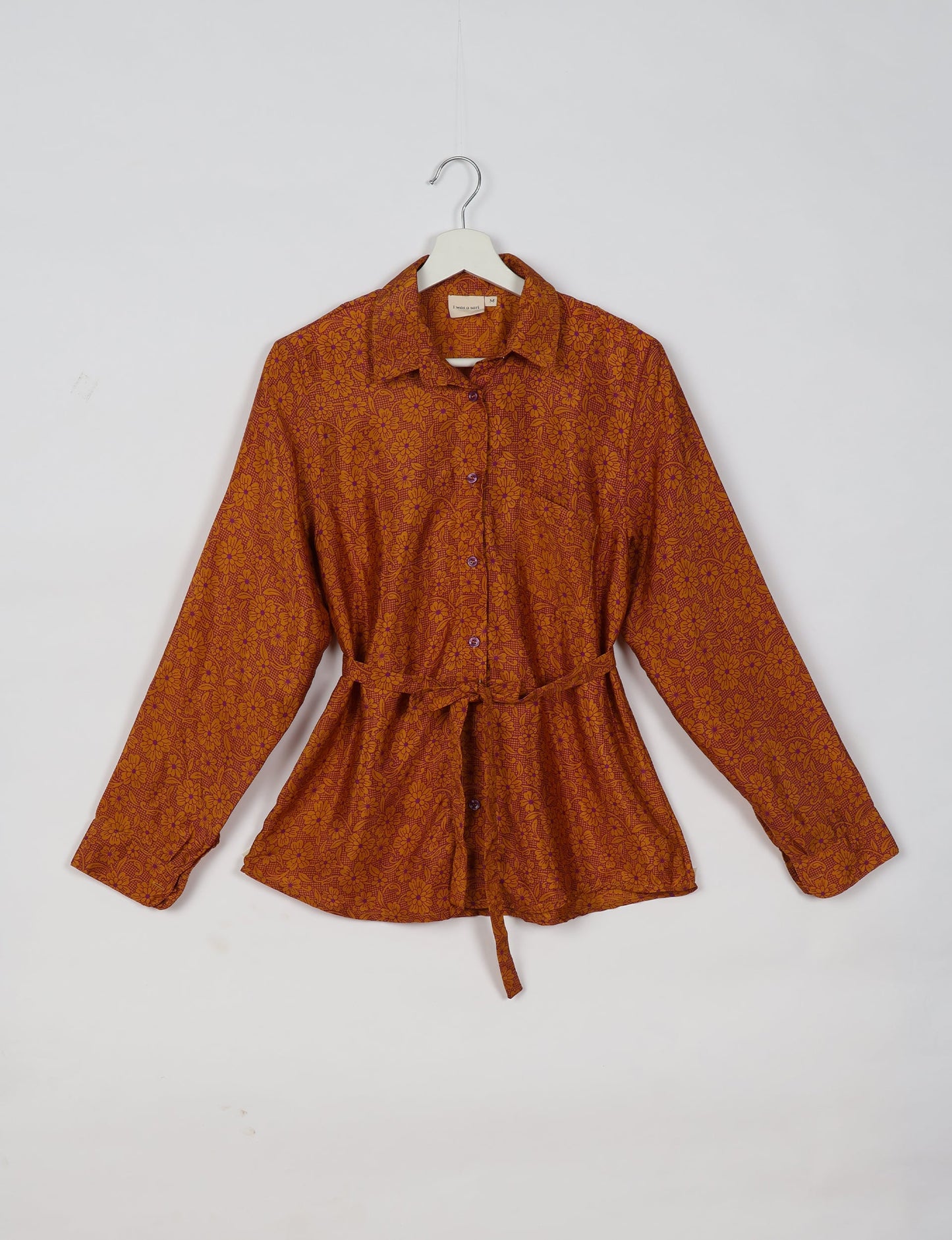 Experience sustainable fashion with our classic slim-fit shirt, crafted with ethical and green values. The shirt, designed for minimal waste, features a tie-up waist belt or neck tie, semi-spread collar, and regular shirt cuffs. Versatile and eco-friendly, wear it tucked in, unbuttoned over a tank top, or knotted at the waist for a unique style.