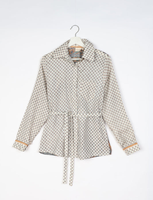 Experience sustainable fashion with our classic slim-fit shirt, crafted with ethical and green values. The shirt, designed for minimal waste, features a tie-up waist belt or neck tie, semi-spread collar, and regular shirt cuffs. Versatile and eco-friendly, wear it tucked in, unbuttoned over a tank top, or knotted at the waist for a unique style.