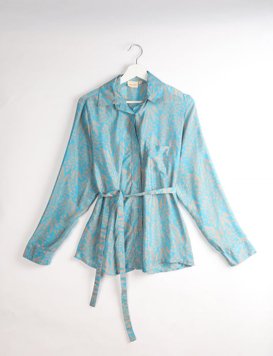 Experience sustainable fashion with our classic slim-fit shirt, crafted with ethical and green values. The shirt, designed for minimal waste, features a tie-up waist belt or neck tie, semi-spread collar, and regular shirt cuffs. Versatile and eco-friendly, wear it tucked in, unbuttoned over a tank top, or knotted at the waist for a unique style.