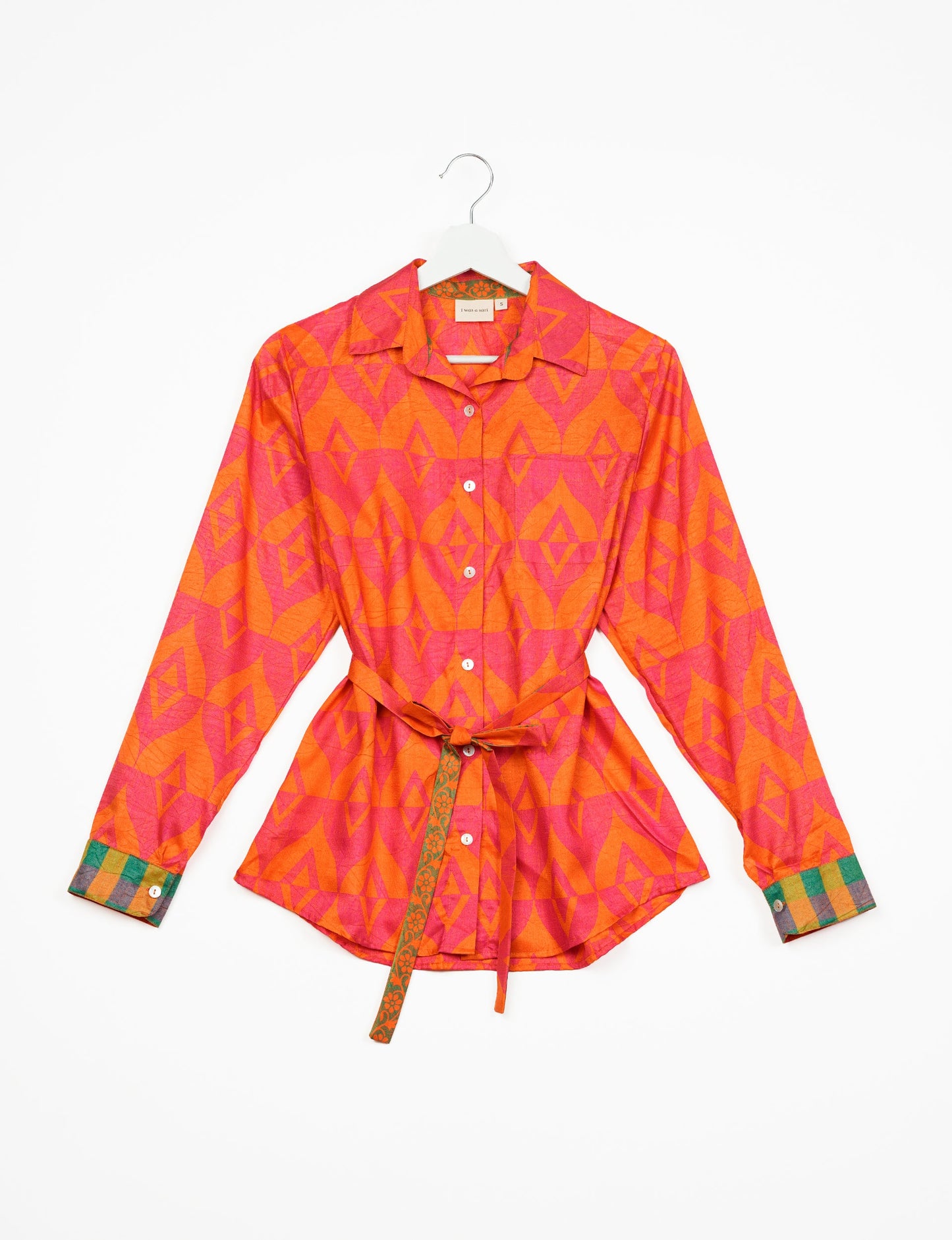 Experience sustainable fashion with our classic slim-fit shirt, crafted with ethical and green values. The shirt, designed for minimal waste, features a tie-up waist belt or neck tie, semi-spread collar, and regular shirt cuffs. Versatile and eco-friendly, wear it tucked in, unbuttoned over a tank top, or knotted at the waist for a unique style.