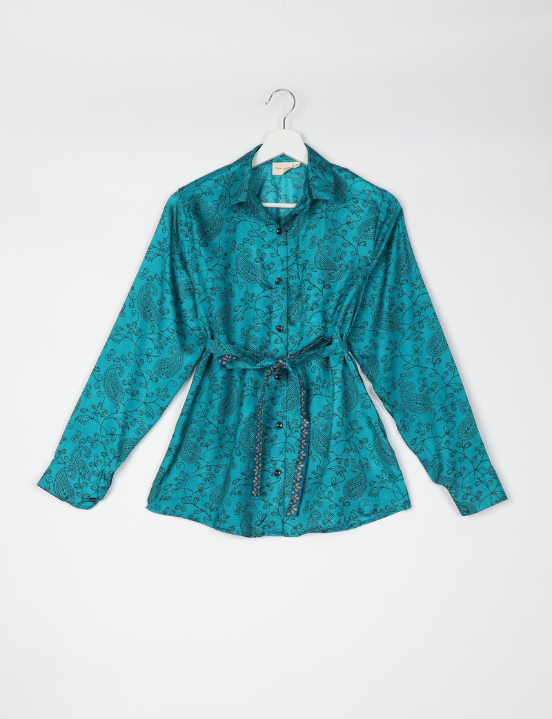 Blue long-sleeve button-up shirt with black tropical paisley print and matching fabric belt, shown on white hanger