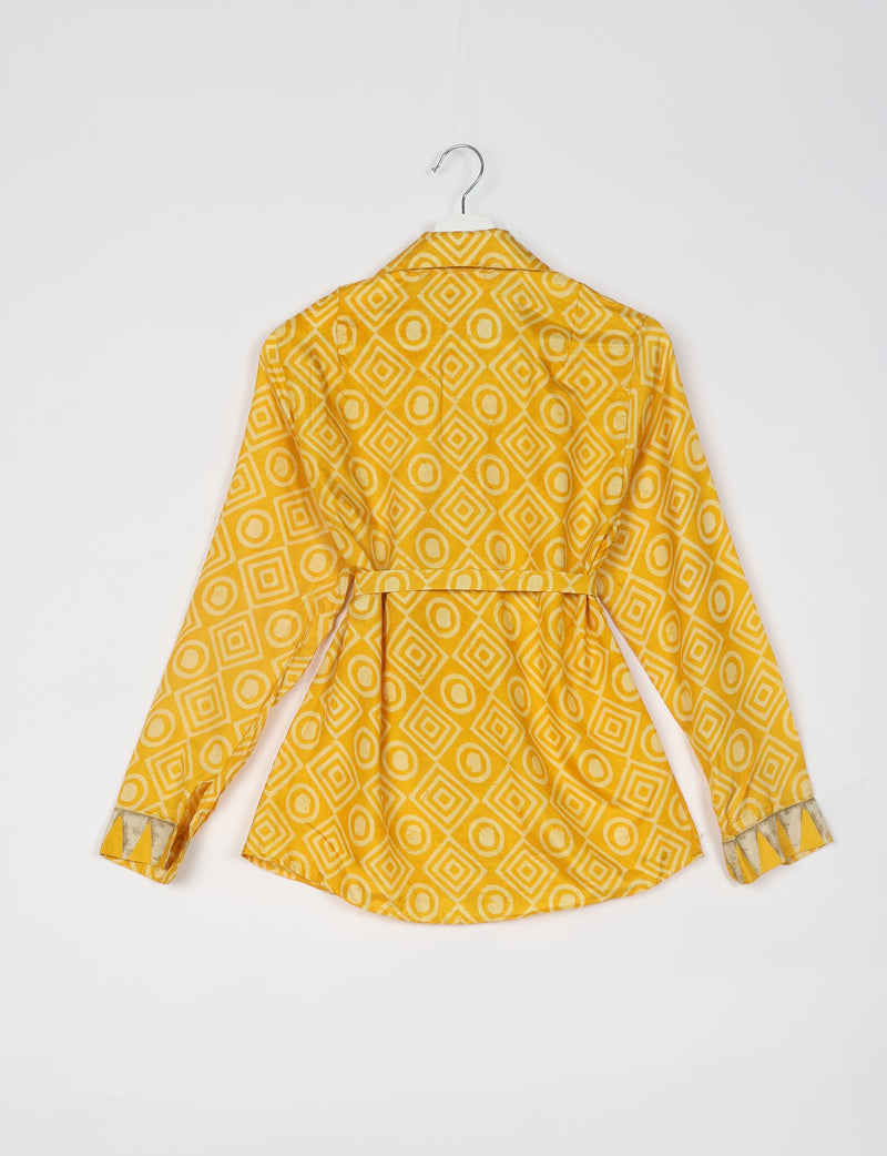 Yellow long-sleeve shirt with geometric diamond and circle pattern, back view, hanging on white hanger against white background