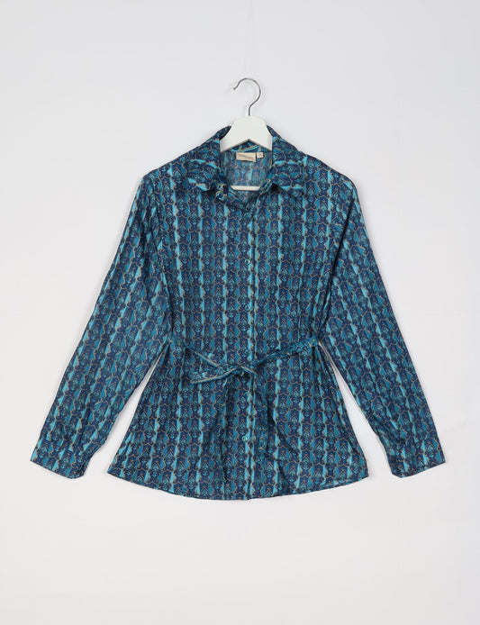 Experience sustainable fashion with our classic slim-fit shirt, crafted with ethical and green values. The shirt, designed for minimal waste, features a tie-up waist belt or neck tie, semi-spread collar, and regular shirt cuffs. Versatile and eco-friendly, wear it tucked in, unbuttoned over a tank top, or knotted at the waist for a unique style.