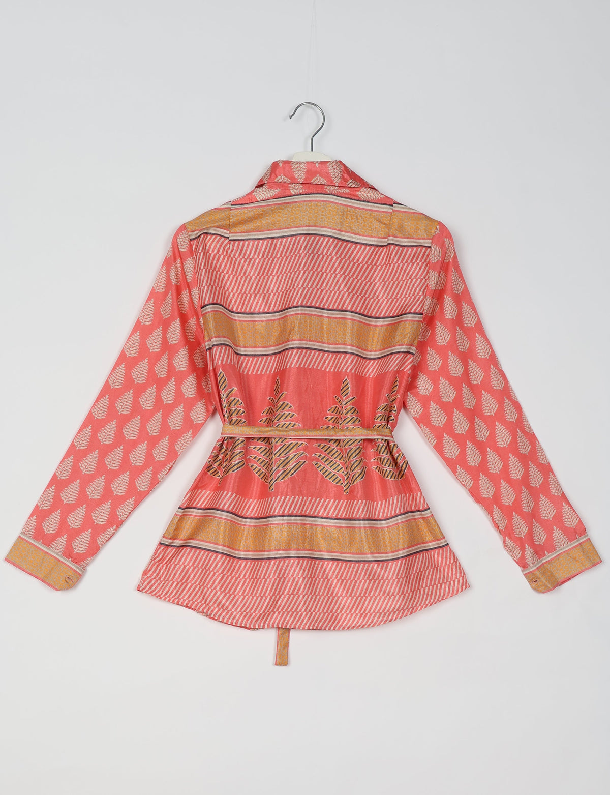 Coral pink ethnic shirt with leaf and stripe patterns, long sleeves, collar, and belt, shown from back on hanger