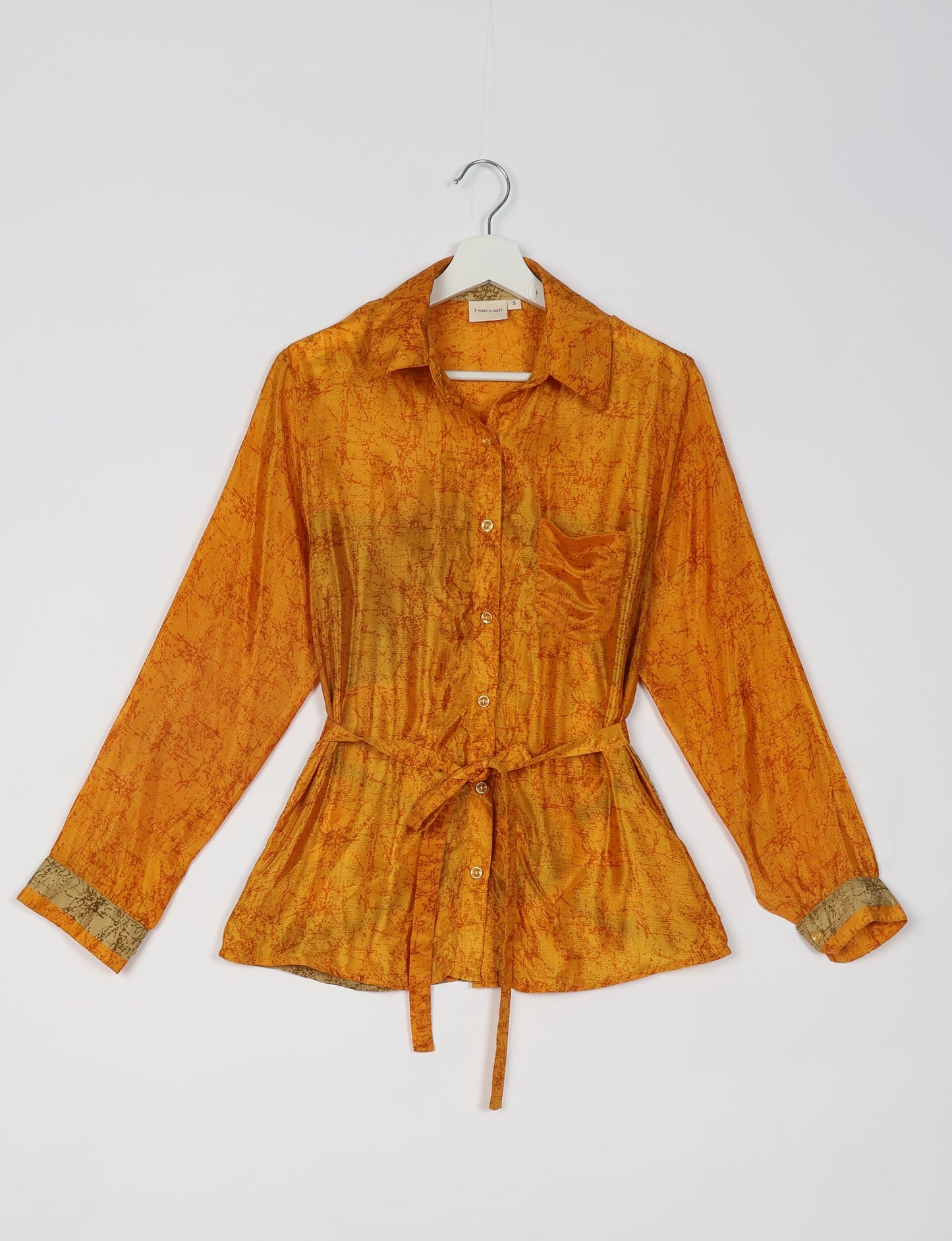 Experience sustainable fashion with our classic slim-fit shirt, crafted with ethical and green values. The shirt, designed for minimal waste, features a tie-up waist belt or neck tie, semi-spread collar, and regular shirt cuffs. Versatile and eco-friendly, wear it tucked in, unbuttoned over a tank top, or knotted at the waist for a unique style.