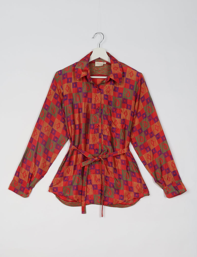 Red ethnic patterned long-sleeve shirt with collar, buttons, front pocket, and waist tie, hanging on a white hanger