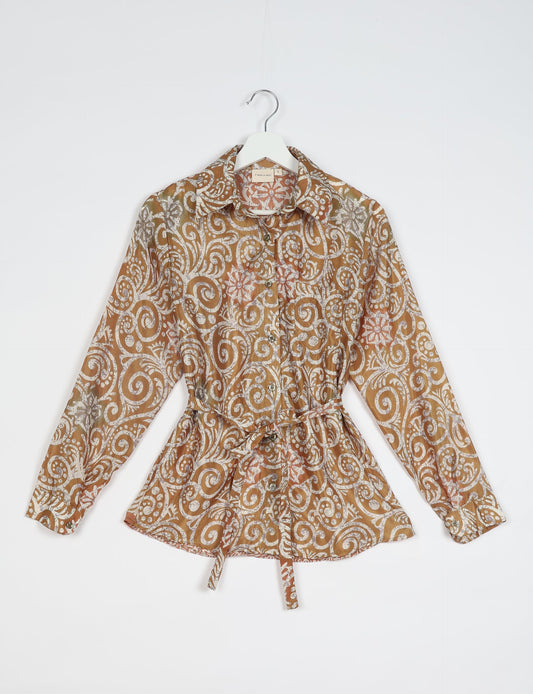 Experience sustainable fashion with our classic slim-fit shirt, crafted with ethical and green values. The shirt, designed for minimal waste, features a tie-up waist belt or neck tie, semi-spread collar, and regular shirt cuffs. Versatile and eco-friendly, wear it tucked in, unbuttoned over a tank top, or knotted at the waist for a unique style.