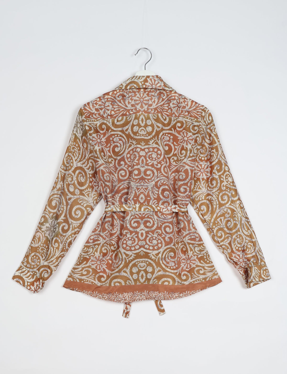 Brown ethnic patterned long-sleeve shirt with collar and belt, shown from the back on a hanger