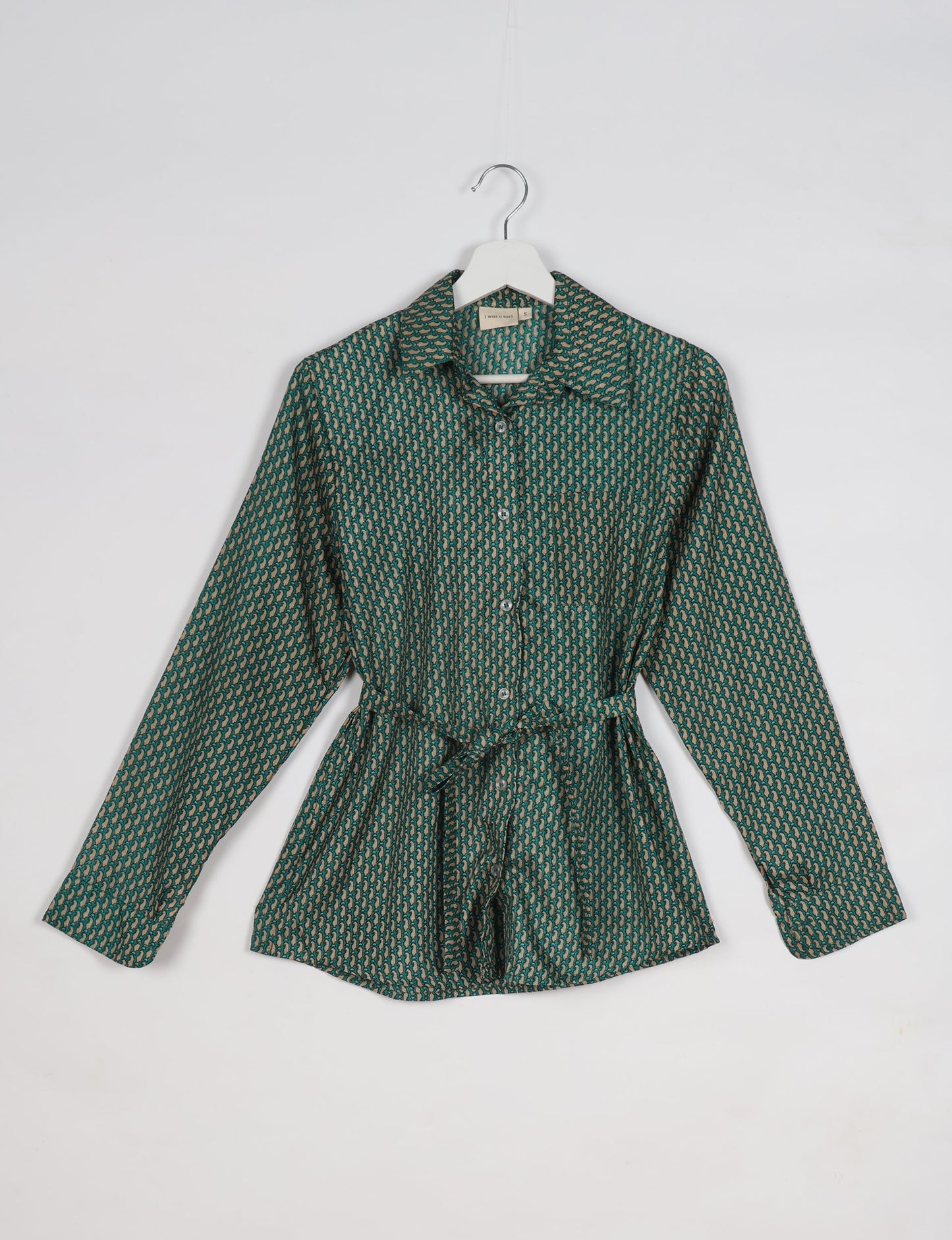 Experience sustainable fashion with our classic slim-fit shirt, crafted with ethical and green values. The shirt, designed for minimal waste, features a tie-up waist belt or neck tie, semi-spread collar, and regular shirt cuffs. Versatile and eco-friendly, wear it tucked in, unbuttoned over a tank top, or knotted at the waist for a unique style.