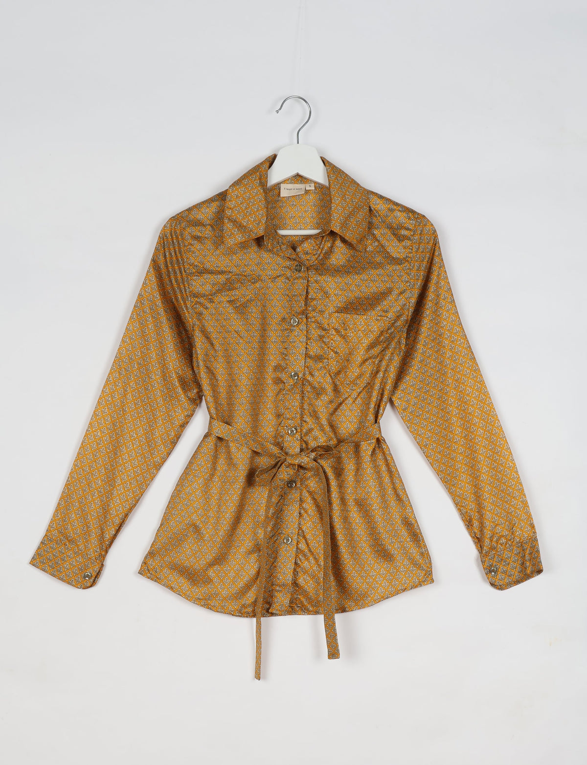 Experience sustainable fashion with our classic slim-fit shirt, crafted with ethical and green values. The shirt, designed for minimal waste, features a tie-up waist belt or neck tie, semi-spread collar, and regular shirt cuffs. Versatile and eco-friendly, wear it tucked in, unbuttoned over a tank top, or knotted at the waist for a unique style.