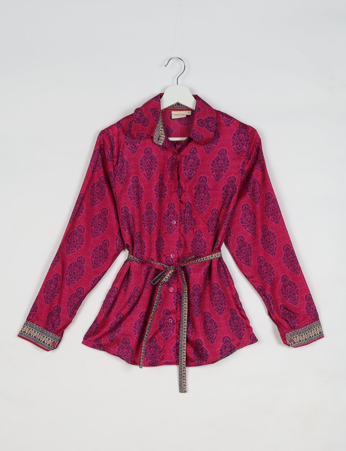 Experience sustainable fashion with our classic slim-fit shirt, crafted with ethical and green values. The shirt, designed for minimal waste, features a tie-up waist belt or neck tie, semi-spread collar, and regular shirt cuffs. Versatile and eco-friendly, wear it tucked in, unbuttoned over a tank top, or knotted at the waist for a unique style.