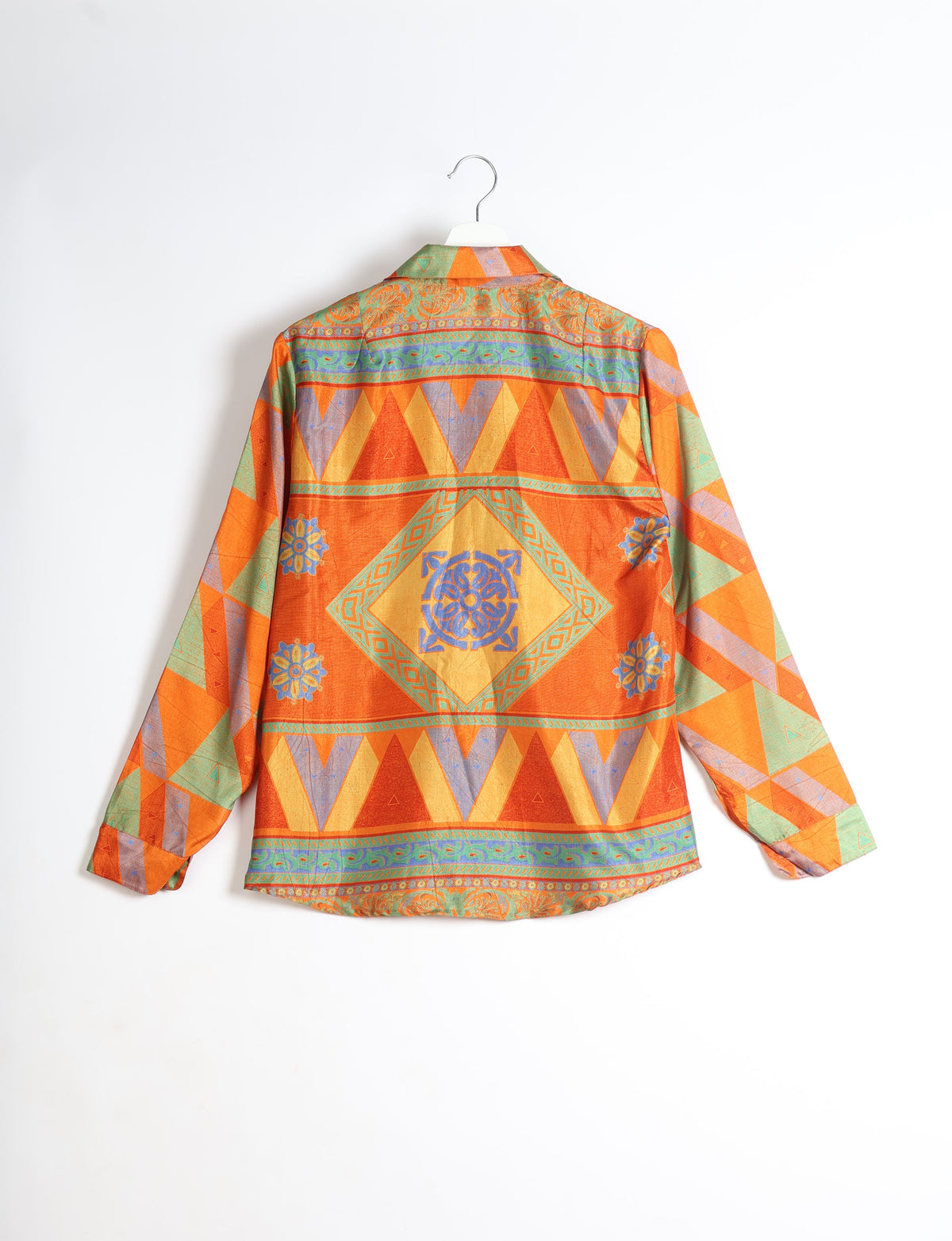 Long-sleeve shirt with orange, green, purple, and yellow geometric and floral patterns, shown from back on hanger