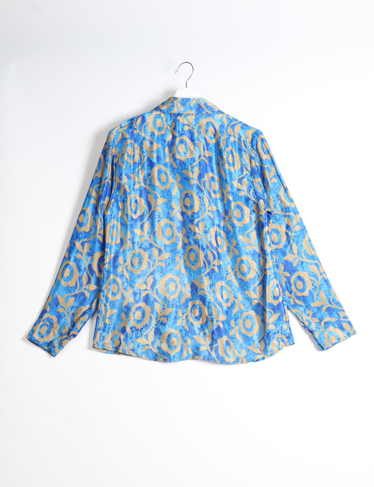 Blue long-sleeve shirt with beige floral pattern, shown from back, hanging on white hanger against white background