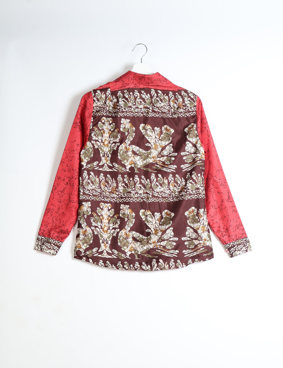 Red long-sleeve shirt with abstract floral pattern on back and cuffs, shown hanging from a white hanger