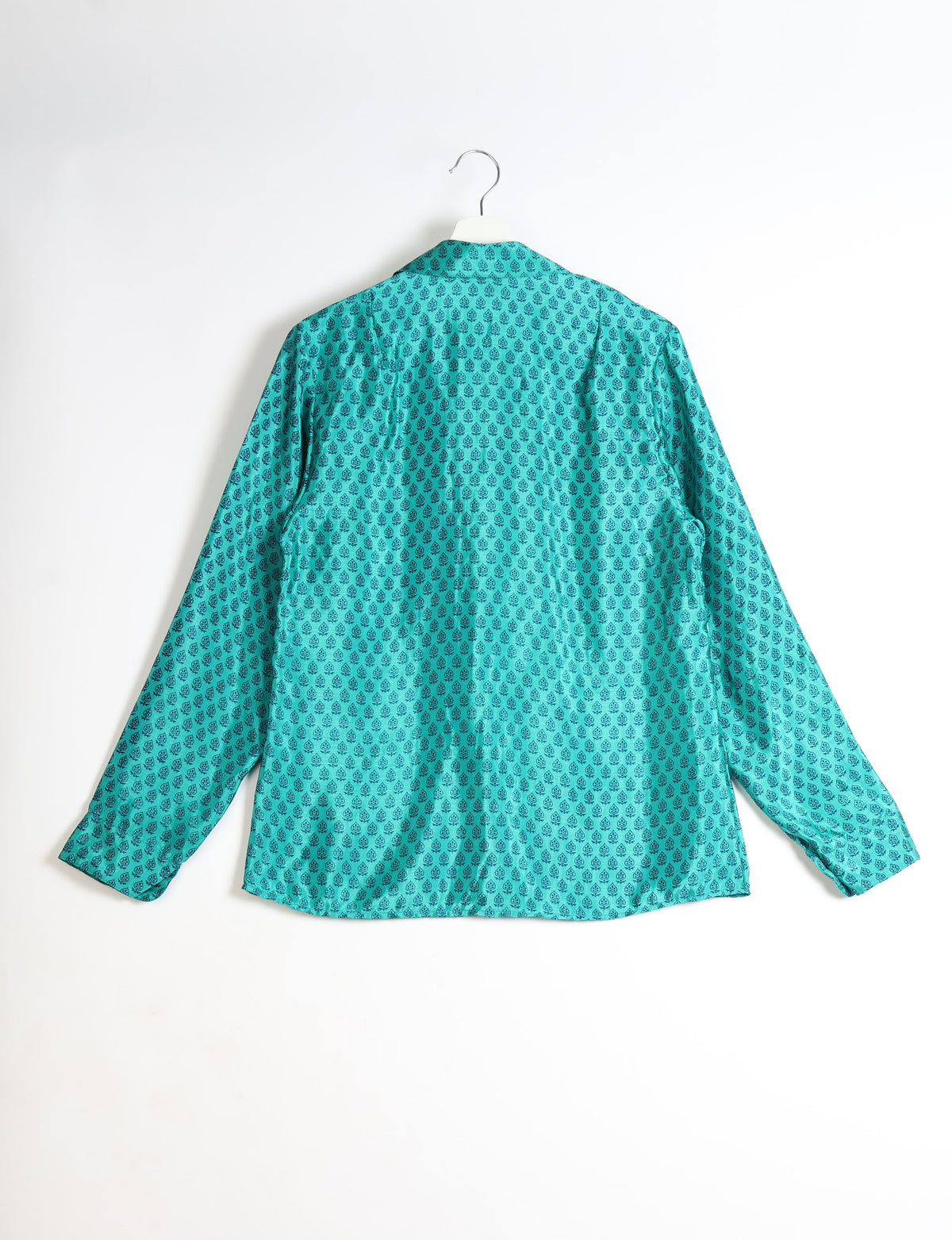 Turquoise long-sleeve shirt with black micro floral pattern, shown from back, hanging on white hanger against white background