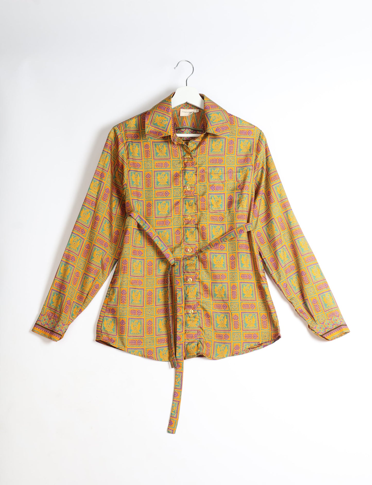 Experience sustainable fashion with our classic slim-fit shirt, crafted with ethical and green values. The shirt, designed for minimal waste, features a tie-up waist belt or neck tie, semi-spread collar, and regular shirt cuffs. Versatile and eco-friendly, wear it tucked in, unbuttoned over a tank top, or knotted at the waist for a unique style.