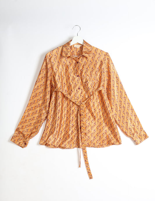 Experience sustainable fashion with our classic slim-fit shirt, crafted with ethical and green values. The shirt, designed for minimal waste, features a tie-up waist belt or neck tie, semi-spread collar, and regular shirt cuffs. Versatile and eco-friendly, wear it tucked in, unbuttoned over a tank top, or knotted at the waist for a unique style.