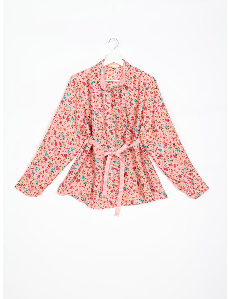 Pink long-sleeve button-up shirt with blue and red floral print, collar, and matching fabric belt, shown flat on hanger