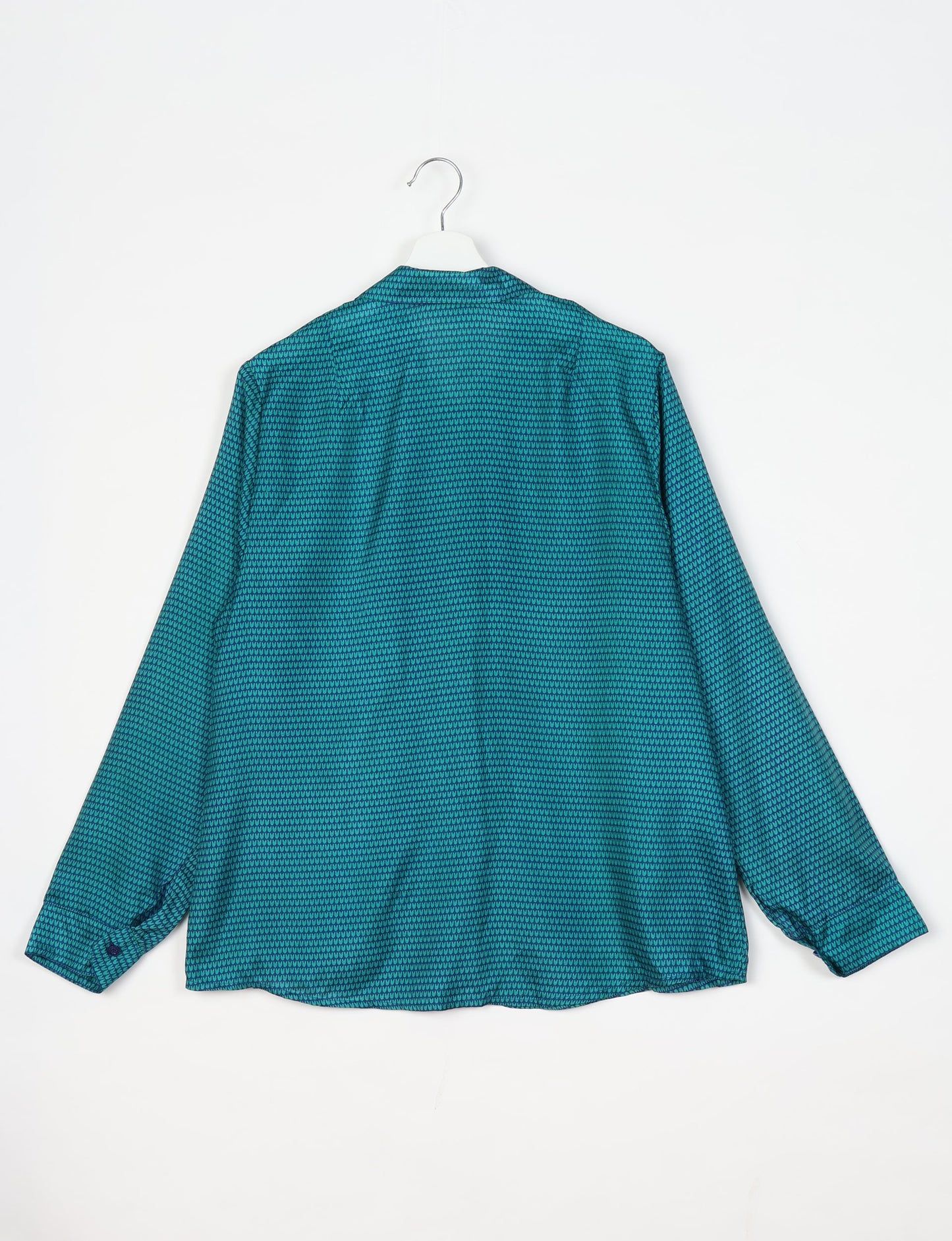 Experience sustainable fashion with our classic slim-fit shirt, crafted with ethical and green values. The shirt, designed for minimal waste, features a tie-up waist belt or neck tie, semi-spread collar, and regular shirt cuffs. Versatile and eco-friendly, wear it tucked in, unbuttoned over a tank top, or knotted at the waist for a unique style.
