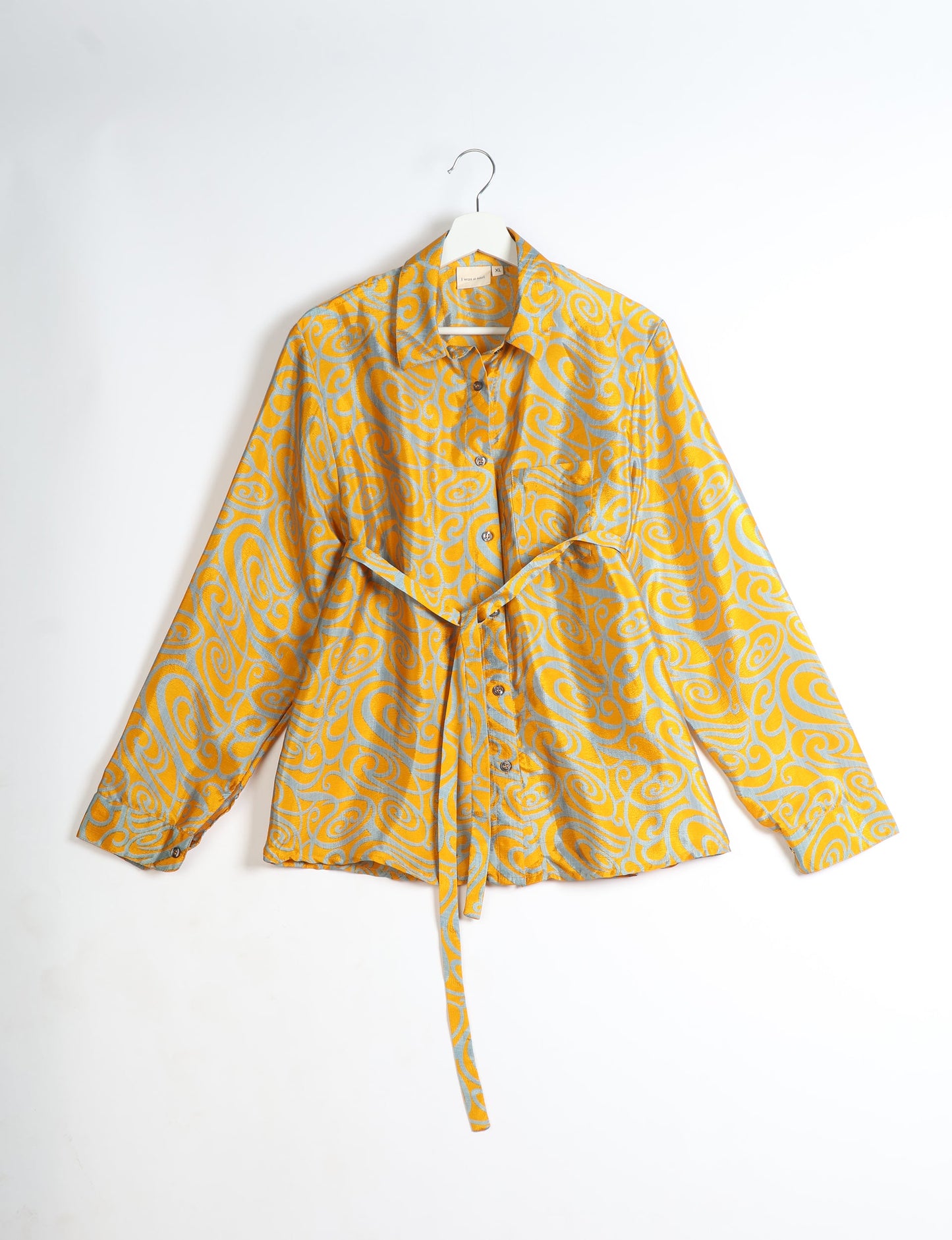 Experience sustainable fashion with our classic slim-fit shirt, crafted with ethical and green values. The shirt, designed for minimal waste, features a tie-up waist belt or neck tie, semi-spread collar, and regular shirt cuffs. Versatile and eco-friendly, wear it tucked in, unbuttoned over a tank top, or knotted at the waist for a unique style.